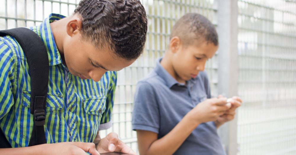 kids texting message in Facebook on smartphone